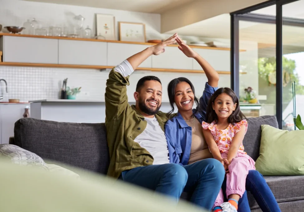 1746089411877_GettyImages-2172316443-c4ffbcc Happy family sitting on a couch together.